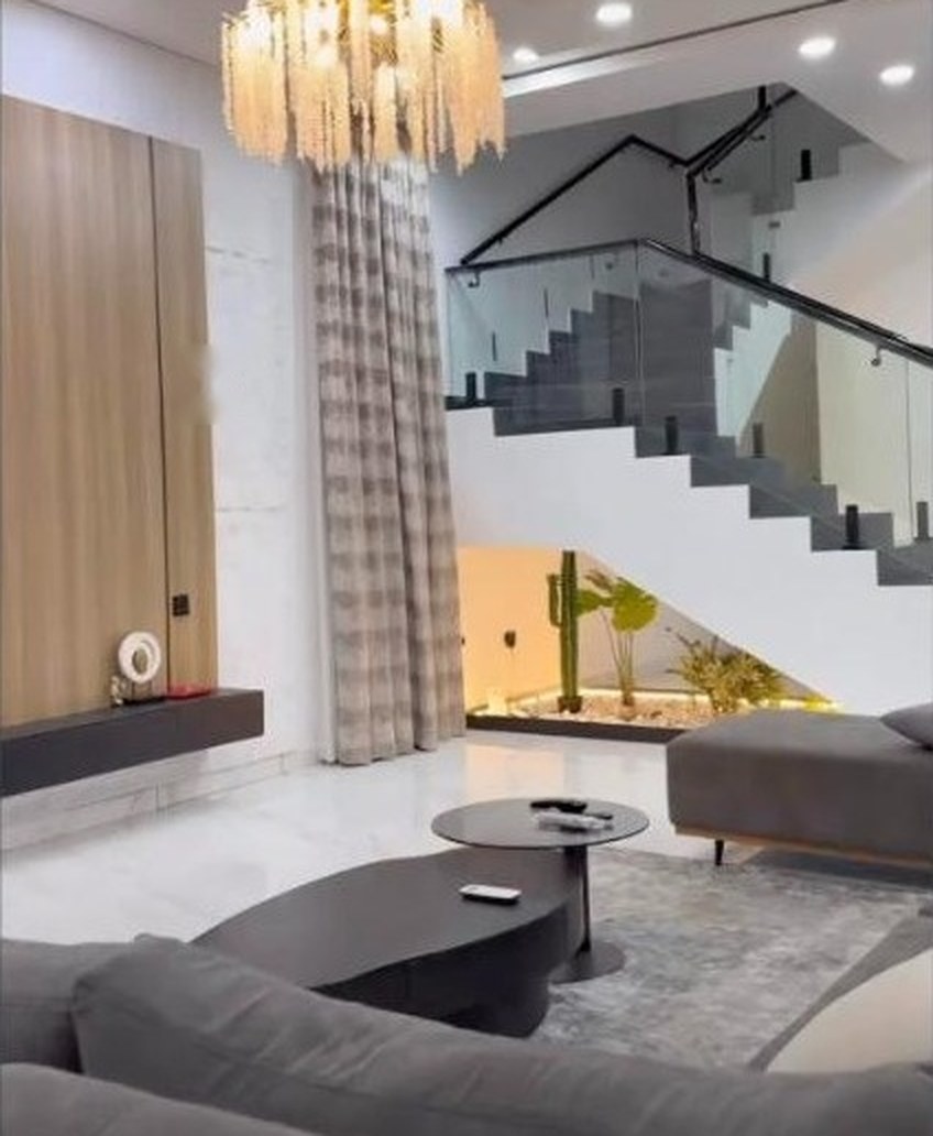 Sitting room with chandelier and glass staircase